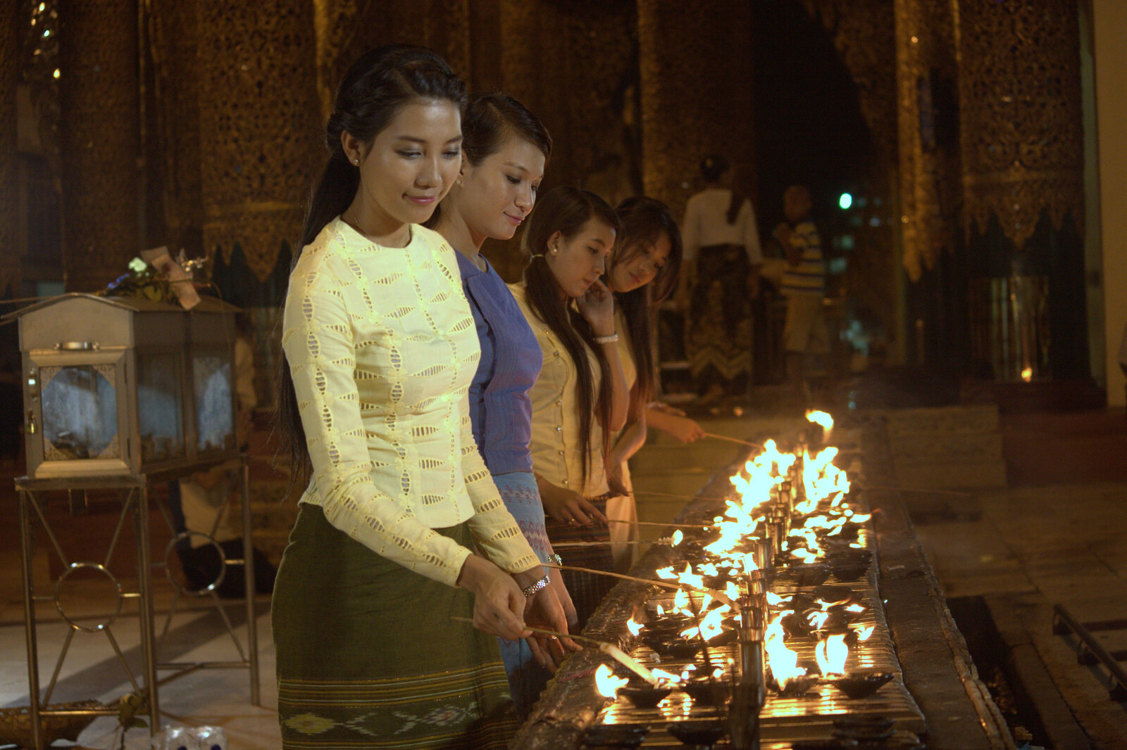 Women lighting candles at Shwedagon Pagoda at night
